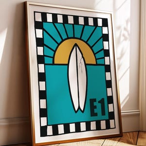 Könnte beinhalten: Gerahmter Kunstdruck mit einem Surfbrett-Design. Das Kunstwerk zeigt ein weißes Surfbrett vor einem türkisfarbenen Hintergrund, mit einer gelben Sonne und einem schwarz-weißen Rand. Der Druck enthält den Text "E1".