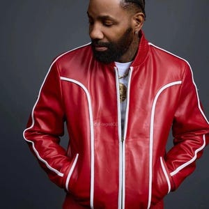 May include: A red leather jacket and matching trousers set, featuring white trim. The jacket has a zip and pockets. This stylish outfit is a bold fashion statement. The image includes the text "deForgedCC".