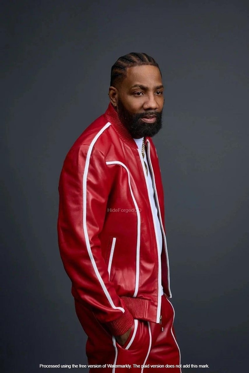 May include: A red track suit with white stripes. The jacket has a zip closure and the trousers have pockets. The outfit is made of a shiny material. The person is wearing a white shirt underneath the jacket.