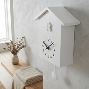 May include: A white ceramic mug with a black handle and the text "But First, Coffee" in a handwritten style. The mug is on a white surface. The mug is approximately 4 inches tall.