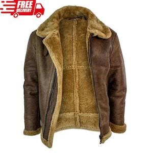 May include: A brown jacket with a thick tan shearling lining and collar. The jacket features a front zip fastening, long sleeves with shearling cuffs, and a textured exterior finish. The interior is fully lined with soft, tan-coloured shearling.