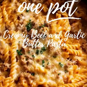 Puede incluir: Primer plano de una olla llena de pasta cremosa con carne de res y mantequilla de ajo. La pasta tiene forma de espiral, cubierta con una salsa cremosa y queso derretido. El texto "one pot" y "Creamy Beef and Garlic Butter Pasta" son visibles.