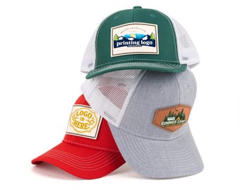May include: Three trucker caps stacked. The top one is green with a white mesh back and a patch reading "printing logo". The middle cap is grey with a white mesh back. The bottom cap is red with a patch that says "logo in here".