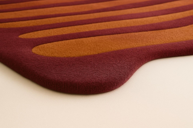 Close up of hand tufted wool rug showing thick plush pile and curved sculpted border detail.