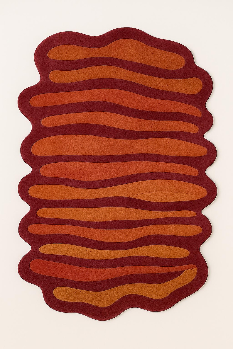 Top view of abstract melted shape rug in burnt orange and deep red tones with organic wavy striped pattern.