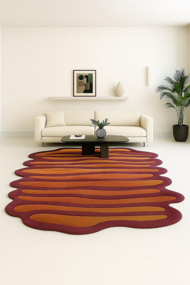 Wavy irregular burnt orange and rust hand tufted wool area rug styled in a modern living room with cream sofa and black coffee table.