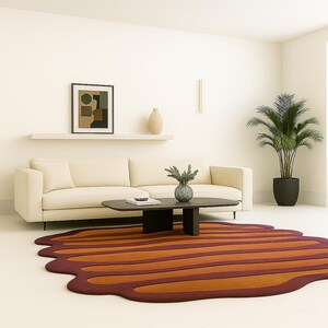 Wide living room shot featuring burnt orange irregular rug paired with modern cream couch and indoor plant.