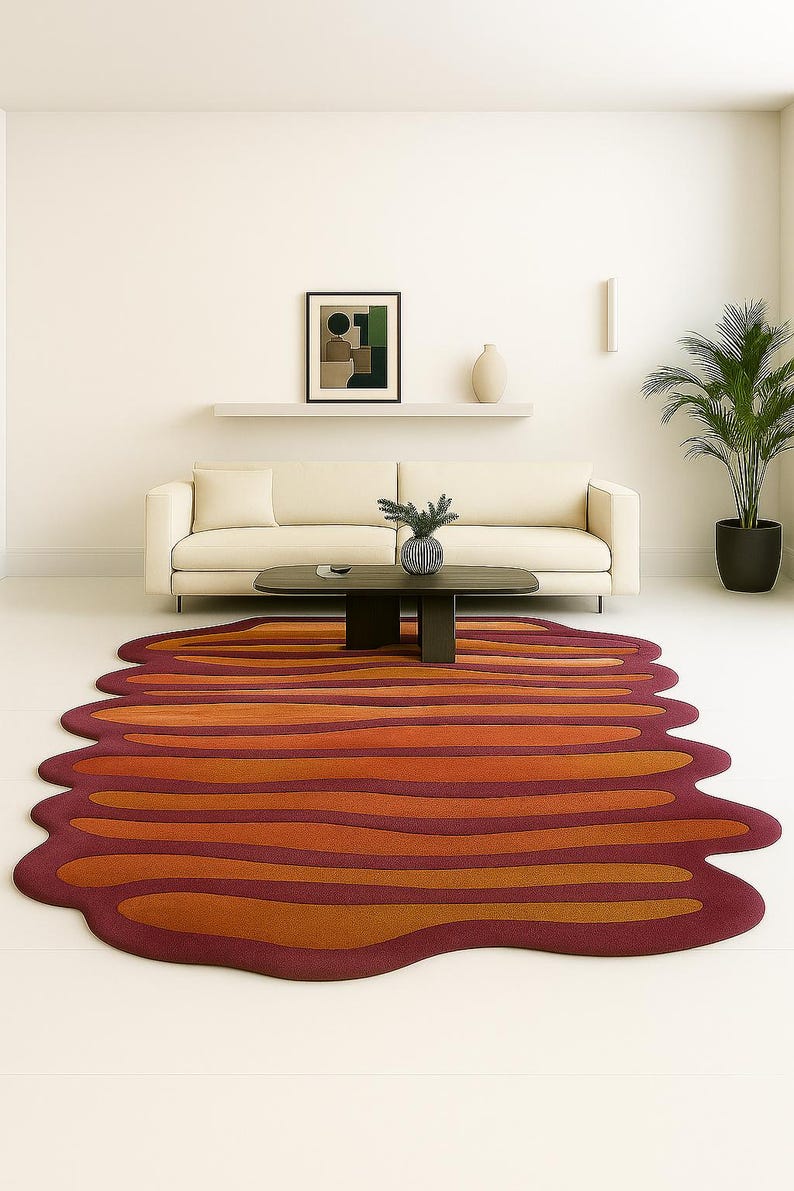 Irregular edge wool rug with layered wave design in rust and orange tones styled in minimalist decor space.