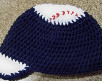Può includere: Cappellino da baseball all'uncinetto blu navy, bianco e rosso. Il cappellino presenta una corona e una visiera blu navy, con dettagli bianchi che imitano una palla da baseball. Le cuciture rosse dettagliano il design della palla da baseball bianca.