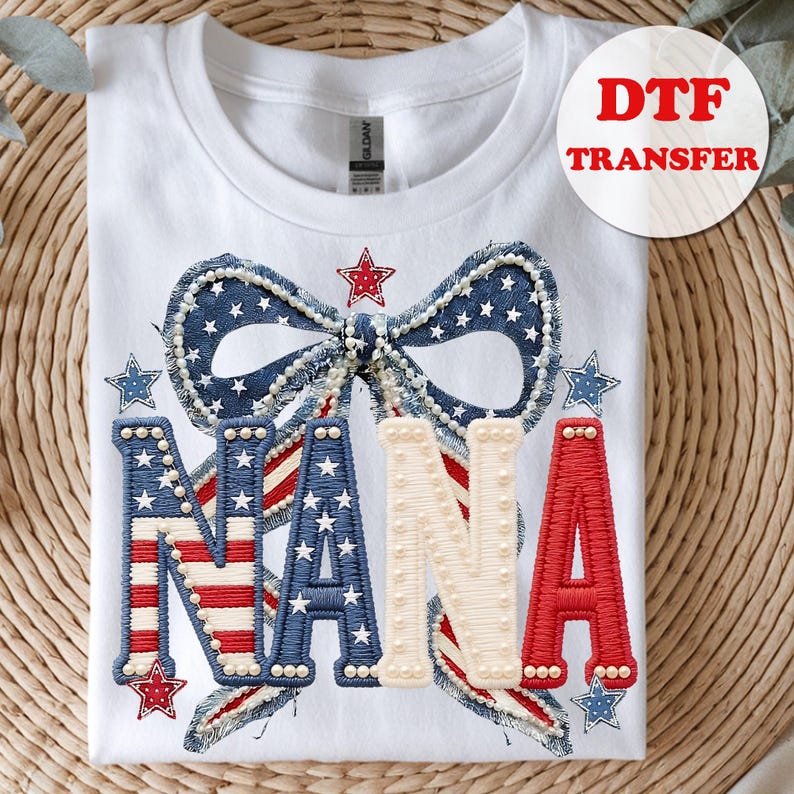 May include: White t-shirt with a patriotic design featuring the word "NANA" in red, white, and blue, with a bow and stars. The design includes the text "DTF TRANSFER" in a red circle.