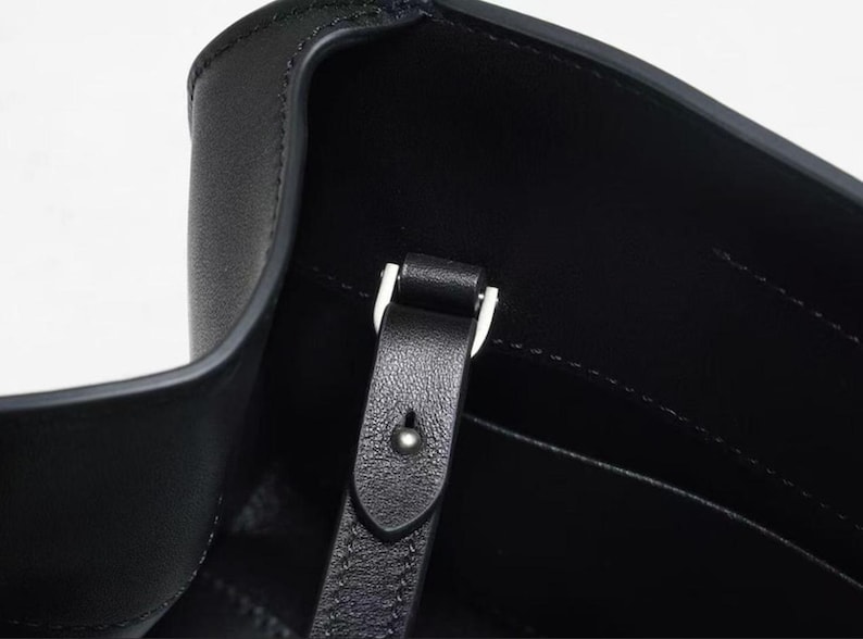 Sleek black minimalist leather shoulder bag with baguette handbag shape, structured leather bag featuring soft genuine leather and top handle design, convertible crossbody bag with detachable strap, aesthetic pinterest bag inspired by 90s baguette bag trend, everyday bag for daily essentials, zipper closure leather purse with compact storage, elegant classic handbag with quiet luxury style, minimalist work bag and trendy everyday bag, women leather bag perfect as gift for women