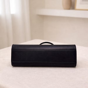 Black leather baguette handbag with minimalist design and structured silhouette, women shoulder bag crafted from soft genuine leather, top handle bag with detachable strap for crossbody wear, elegant aesthetic bag inspired by vintage baguette bag and 90s underarm bag trend, everyday bag with zipper closure for essentials, sleek and slim leather purse ideal for minimalist work bag use, classic handbag with quiet luxury appeal, trendy everyday bag and thoughtful gift for women