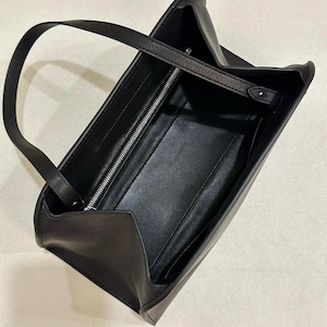 Black minimalist leather baguette bag with clean structured silhouette, women shoulder bag featuring soft genuine leather and sleek top handle design, elegant handbag inspired by 90s baguette bag and underarm bag trend, aesthetic pinterest bag perfect as everyday bag or minimalist work bag, zipper closure leather purse with compact storage, convertible crossbody bag option, classic handbag with quiet luxury style, trendy everyday bag for modern outfits, ideal gift for women