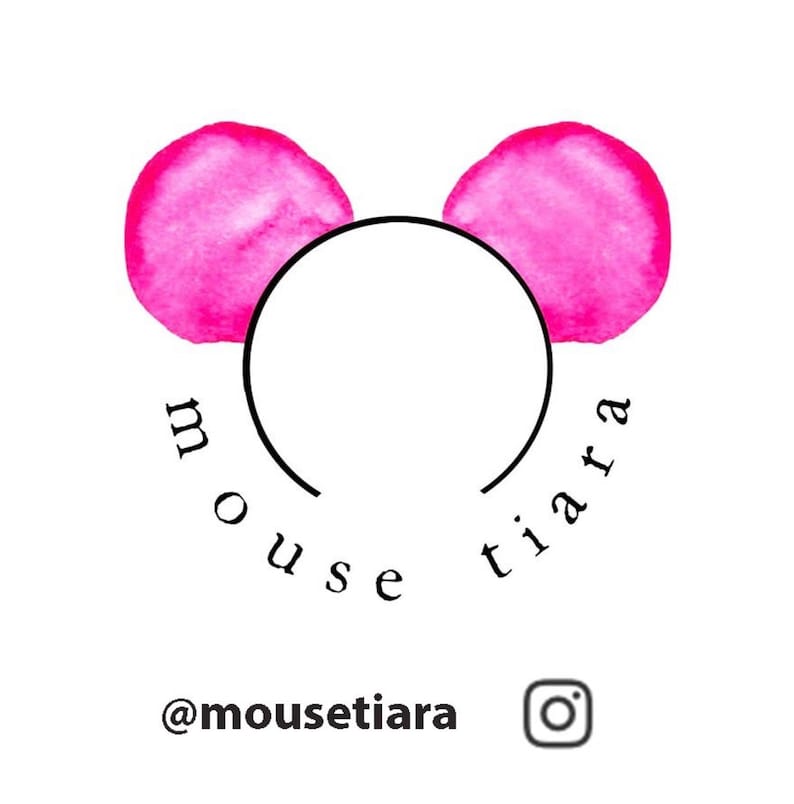 May include: A black headband with two pink watercolor mouse ears. The text "mouse tiara" is written below the headband. The social media handle "@mousetiara" and an Instagram icon are below the text.