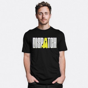 Op de afbeelding: Zwart t-shirt met het woord "DISPATCH" in witte blokletters en een gele bliksemstraal. Het shirt heeft korte mouwen en is gemaakt van een zacht materiaal.