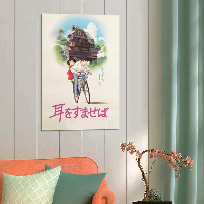 May include: A poster featuring an anime-style illustration of two people riding a bicycle. The background shows a house on a hill under a blue sky. The poster has Japanese text in pink.