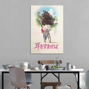 May include: A framed poster featuring an anime scene. The artwork depicts a boy and girl riding a bicycle, with a large house in the background. Japanese text is visible at the bottom of the poster.