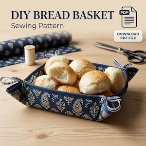 Puede incluir: Un patrón de costura PDF para una panera DIY, que muestra una cesta de tela azul oscuro con estampado de cachemira dorada, atada en las esquinas con cintas a rayas y llena de panecillos redondos. Texto incluido: DIY BREAD BASKET Sewing Pattern.