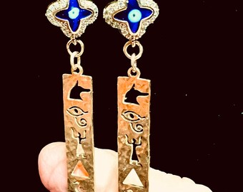 Gold filled charms with jewelers brass drops that have hieroglyphs cut outs.