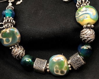 Iridescent green-blue and ivory glass beads made by yours truly.with sterling silver and crystal box clasp. B4