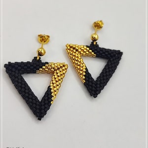 May include: A pair of gold and black triangle earrings. The earrings are made of small beads and have a geometric design.