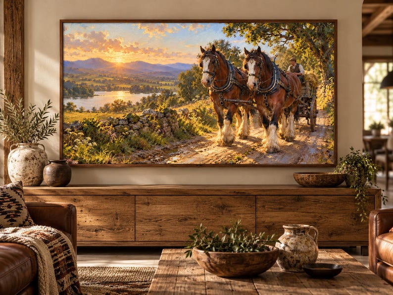 Puede incluir: Un cuadro de paisaje enmarcado que representa a dos caballos de tiro marrones tirando de un carro de madera con un conductor por un camino de tierra. La escena muestra una puesta de sol sobre un r&iacute;o, colinas y un muro de piedra.