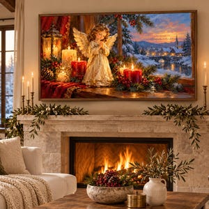 Puede incluir: Un cuadro decorativo enmarcado que muestra una figura de &aacute;ngel con alas de pie entre velas rojas, vegetaci&oacute;n y un farol, con un paisaje de pueblo nevado visible a trav&eacute;s de una ventana al fondo, colgado sobre una chimenea de piedra encendida.