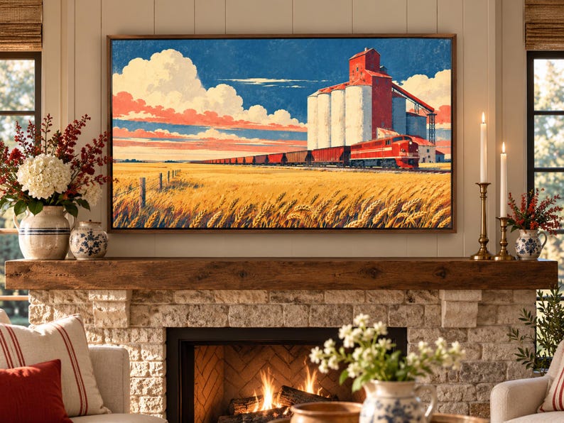 May include: A rectangular wall art print featuring a landscape painting of a red train traveling past a large white grain elevator in a golden wheat field under a blue sky with white clouds, framed in a thin brown border above a stone fireplace.