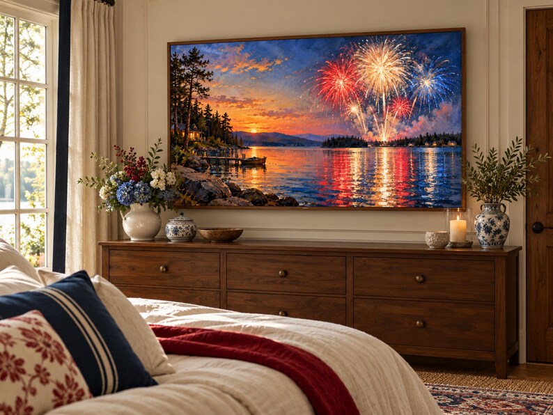 May include: A large rectangular wall art print featuring a vibrant sunset over a lake with colorful fireworks exploding in the sky. The scene includes a dark shoreline with trees, a small boat, and reflections of the fireworks on the water.