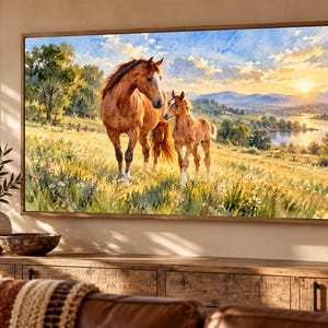 Puede incluir: Un cuadro rectangular con marco de madera que muestra una pintura en acuarela de una yegua marr&oacute;n y su potro en un prado. El fondo presenta colinas, un r&iacute;o tranquilo y un cielo brillante durante la puesta de sol con nubes.