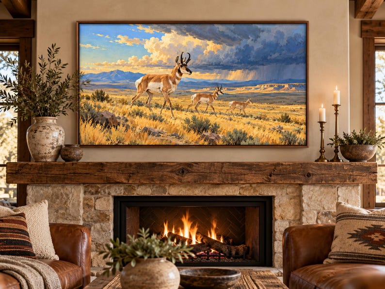 Puede incluir: Una impresi&oacute;n de arte mural rectangular enmarcada que representa tres berrendos caminando por un paisaje de pradera dorada bajo un cielo dram&aacute;tico con nubes de tormenta oscuras y luz solar brillante, montada sobre una chimenea de piedra con repisa.