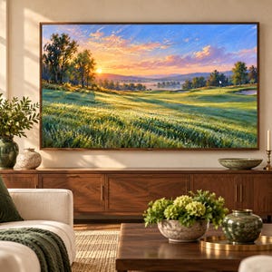 Puede incluir: Una gran pantalla de televisi&oacute;n rectangular montada en la pared muestra una pintura de paisaje de un campo de golf al amanecer con luz dorada, hierba verde y &aacute;rboles bajo un cielo azul y naranja, situada sobre un mueble multimedia de madera.