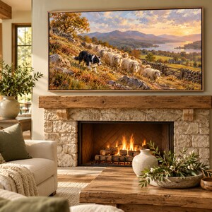 May include: A rectangular wall-mounted television displaying a landscape painting of a border collie herding sheep on a grassy hillside, with a lake and mountains in the background, positioned above a stone fireplace with a wooden mantel.