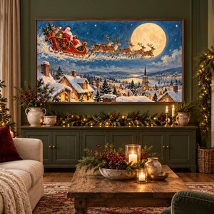 Pu&ograve; includere: Una stampa artistica da parete incorniciata che raffigura Babbo Natale su una slitta trainata da renne che vola attraverso un cielo notturno con una grande luna piena sopra un villaggio innevato, case dettagliate, una chiesa e un fiume.