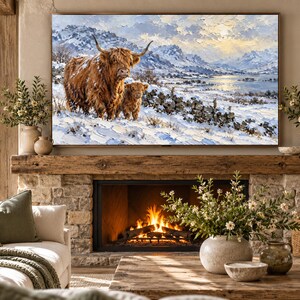 Puede incluir: Una impresi&oacute;n de arte mural rectangular que presenta una pintura al &oacute;leo de una vaca Highland marr&oacute;n peluda y un ternero en un paisaje nevado con monta&ntilde;as y un lago de fondo, exhibida sobre una chimenea de piedra con fuego encendido.