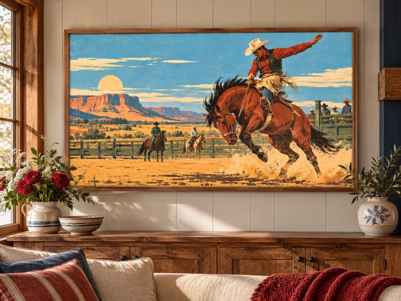 May include: A rectangular wall art print featuring a cowboy riding a bucking brown horse in a desert landscape. The scene includes a bright sun, red rock mesas, a wooden fence, and two other riders in the background under a blue sky.
