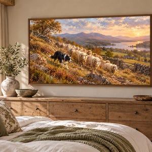 Puede incluir: Un cuadro rectangular de pared con una pintura de paisaje que muestra a un border collie blanco y negro guiando a un reba&ntilde;o de ovejas por una colina. La escena incluye monta&ntilde;as lejanas, un lago y un cielo con luz dorada de atardecer.