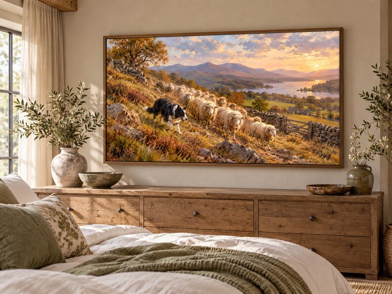 Puede incluir: Un cuadro rectangular de pared con una pintura de paisaje que muestra a un border collie blanco y negro guiando a un reba&ntilde;o de ovejas por una colina. La escena incluye monta&ntilde;as lejanas, un lago y un cielo con luz dorada de atardecer.