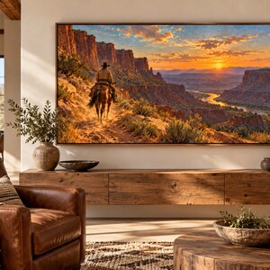 Puede incluir: Un televisor rectangular grande montado en la pared que muestra una pintura de paisaje vibrante de un vaquero a caballo cabalgando a trav&eacute;s de un ca&ntilde;&oacute;n des&eacute;rtico al atardecer, con tonos c&aacute;lidos naranjas, rojos y dorados en el cielo y rocas.