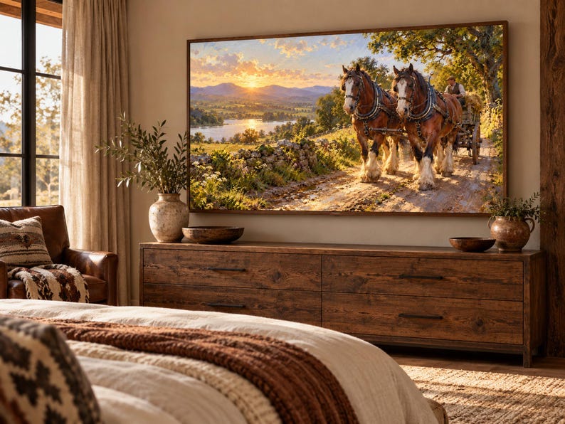 Puede incluir: Una gran pantalla de televisi&oacute;n rectangular montada en la pared muestra una pintura de paisaje de dos caballos de tiro marrones tirando de un carro de madera por un camino de tierra, con una puesta de sol sobre un lago y monta&ntilde;as al fondo, sobre una c&oacute;moda de madera.