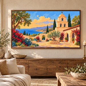 Puede incluir: Un cuadro de paisaje rectangular en marco de madera que representa una escena costera mediterr&aacute;nea con una misi&oacute;n de piedra, un campanario, buganvillas rojas, un olivo y un mar azul bajo un cielo brillante de tonos amarillos y naranjas.
