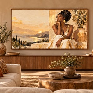 May include: A large rectangular wall art print featuring a split composition. The left side depicts a golden sunset over a coastal landscape with cypress trees. The right side shows a person with dark skin and braided hair wearing a gold dress.