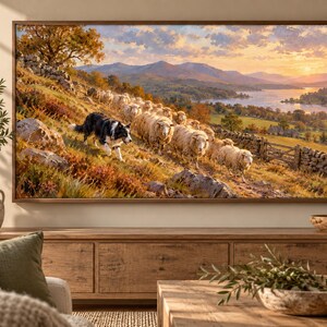 Puede incluir: Una impresi&oacute;n de arte mural rectangular enmarcada que representa un paisaje con un border collie blanco y negro pastoreando un reba&ntilde;o de ovejas por una ladera. El fondo muestra monta&ntilde;as, un lago y un cielo al atardecer con nubes.