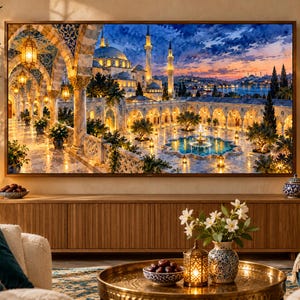 May include: A large rectangular television screen displays a vibrant painting of a mosque courtyard at sunset, featuring arched stone walkways, glowing lanterns, a central fountain, and tall minarets under a deep blue and orange sky.