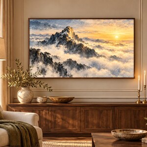 Puede incluir: Un cuadro rectangular de pared que muestra un paisaje de una cumbre nevada sobre una densa capa de nubes al amanecer. La escena incluye formaciones rocosas oscuras y escarpadas y pinos, con un sol dorado brillando en el cielo.