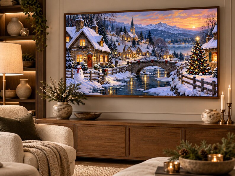 May include: A large rectangular television screen displaying a vibrant winter landscape painting featuring a snow-covered village, a stone bridge over a river, a decorated Christmas tree, and a snowman under a sunset sky with distant mountains.