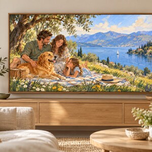 May include: A framed landscape painting depicting a family of three and a golden retriever sitting on a picnic blanket under a tree. The scene features a blue lake, distant mountains, a sailboat, and a grassy meadow filled with yellow and white flowers.