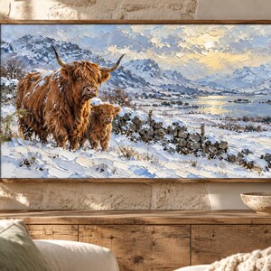 Puede incluir: Un cuadro al &oacute;leo rectangular enmarcado que representa una vaca de las Tierras Altas y su cr&iacute;a en un paisaje nevado. La escena incluye un muro de piedra, monta&ntilde;as lejanas y un lago bajo un cielo brillante con pinceladas gruesas.