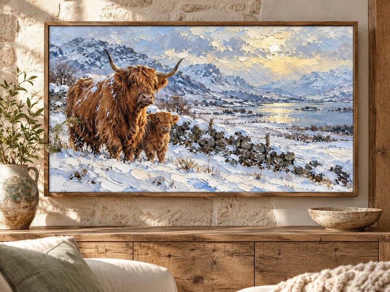 Puede incluir: Un cuadro al &oacute;leo rectangular enmarcado que representa una vaca de las Tierras Altas y su cr&iacute;a en un paisaje nevado. La escena incluye un muro de piedra, monta&ntilde;as lejanas y un lago bajo un cielo brillante con pinceladas gruesas.