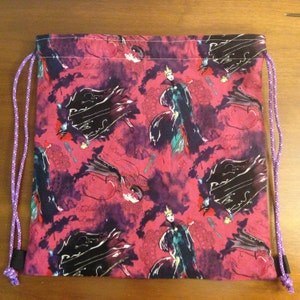 May include: Drawstring bag with a repeating pattern of a cartoon villain in a black cape and crown on a pink background. The words "Fashionably Bad" are printed on the bag. The bag has purple drawstrings.